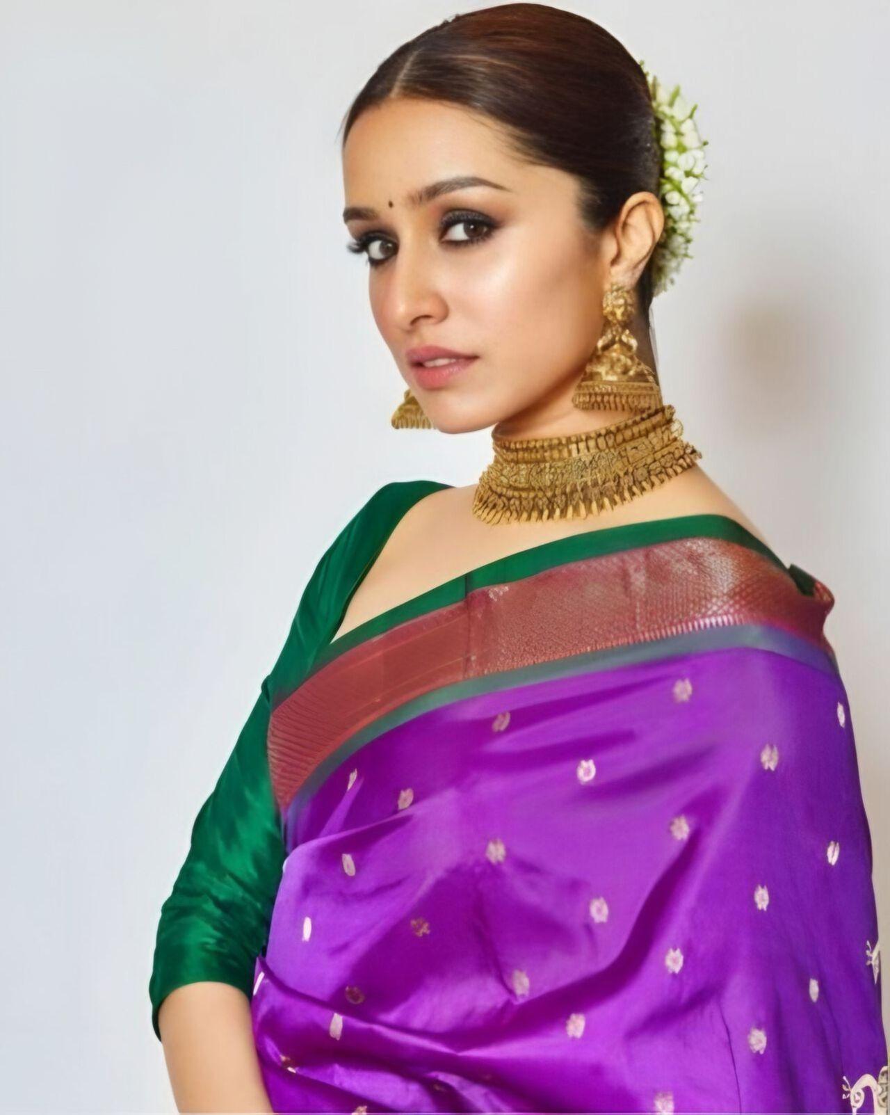 Shraddha Kapoor stuns in a rich purple Paithani, elevated with intricate zari work and a statement choker. The bold hue and minimal styling create a perfect balance of tradition and modern elegance.